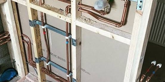 First fix copper pipework run through a boarded stud wall