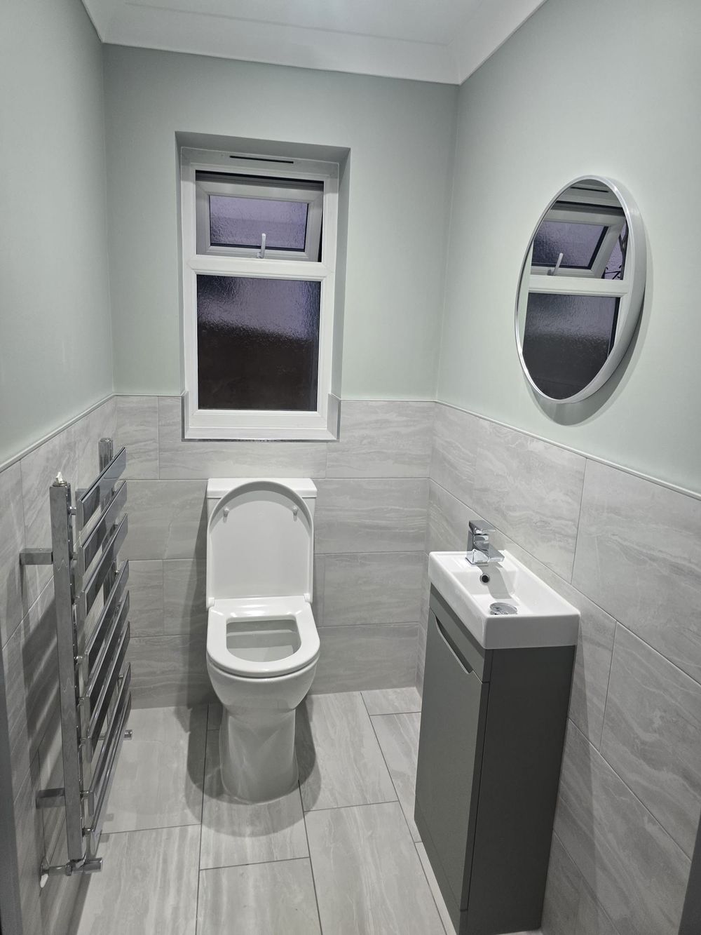 Finished cloakroom WC with sage walls and grey vanity